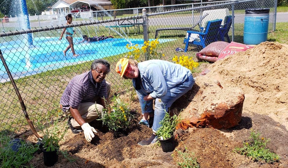 Crestview Citizen of the Year Felton Barnes, and Dr. Cathy Ward, founder of the Common Ground Community Garden, plant flowers in a community garden being established near Fairview Center in Allen Park, located on McClelland Street in Crestview.