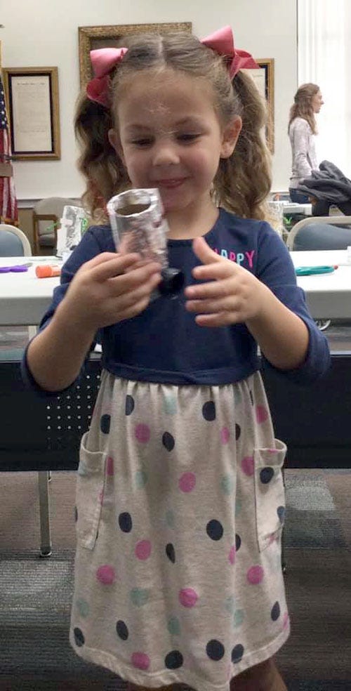 Kalea Willis, age 3, of Crestview, grins at the silly robot she made at Storytime on Wednesday, Oct. 6 at the Crestview Public Library.