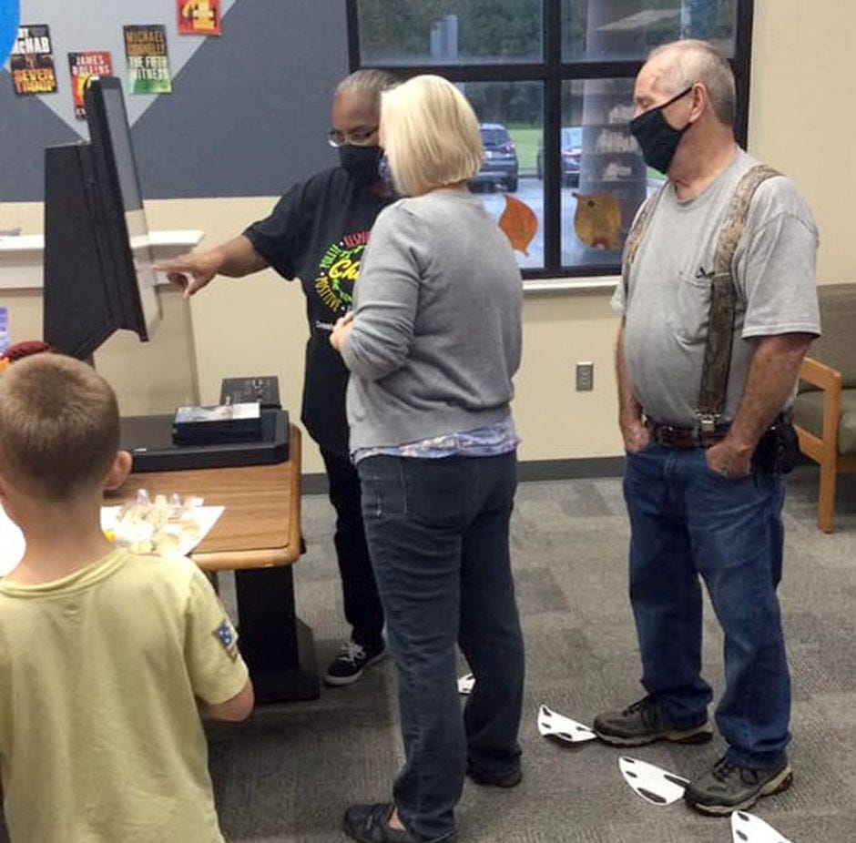 Patrons learn how to use the new self-checkout system at the Crestview Public Library recently.