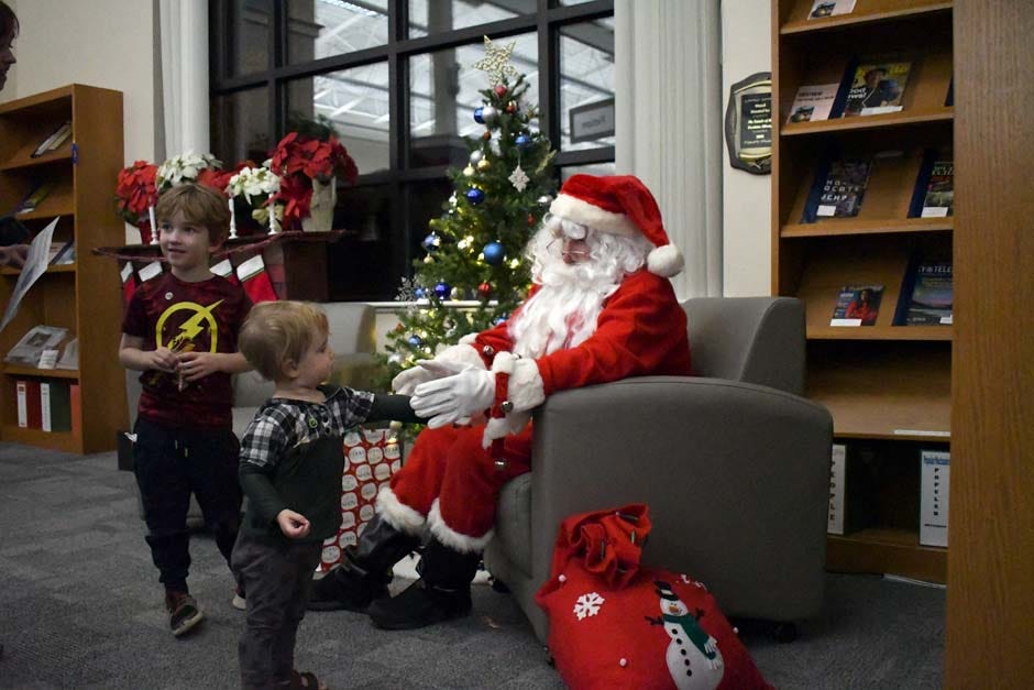 Children spend some time with Santa during the Noel Night event recently at the Crestview Public Library.