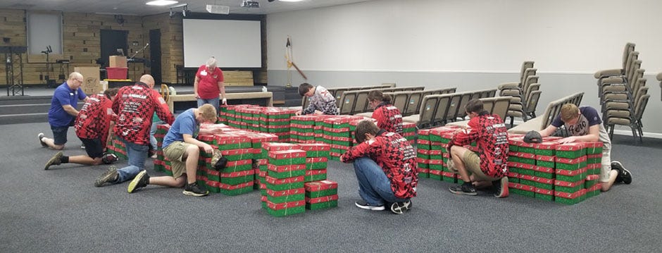 Emerald Coast Youth Bassmasters prayed over Operation Christmas Child boxes as they came in for delivery to the Samaritan's Purse organization.