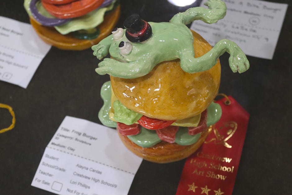 Among Crestview High School Art Show pieces on exhibit at the Crestview Public Library is  Alayna Canlas’s “Frog Burger,” which received the second-place ribbon in the clay sculpture category.