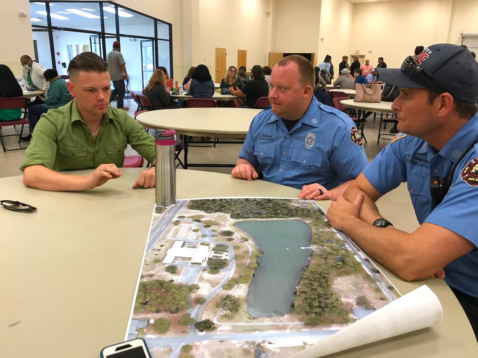 Dako Morfey, an adviser for Crestview’s April 2022 World War II “Hail Our Heroes” weekend, discusses Twin Hills Park fire and pyrotechnic safety precautions for the weekend’s reenactments with Crestview Fire Department Captains Corey Winkler and Matt Cunningham.