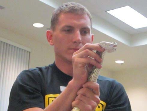 A member of the Army Ranger reptile team holds a snake during a presentation