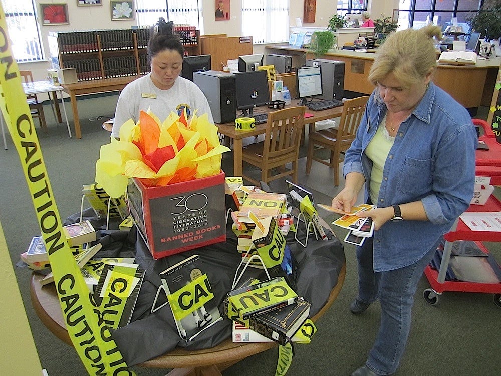 Crestview Public Library staff members Marie Garcia and Annie Whitmore put finishing touches on a display of banned or challenged books for Banned Books Week.