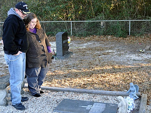 Christopher Patterson and his wife, Jolene Parker Patterson, visit Joshua Devin Kroll's gravesite this week at Old Bethel Cemetery. Multiple items have been taken from her son's grave since his 2005 death, Jolene said.