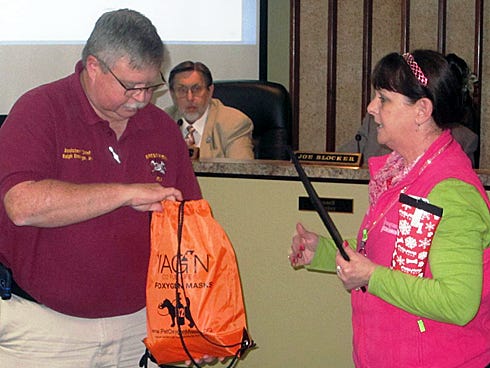 Crestview Assistant Fire Chief Ralph Everage Jr. accepts a donated emergency pet rescue kit from Pawsitively Scrumptious owner April Meier during Monday's City Council meeting.