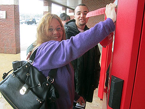 Dina Scott and her son Branden select movies from the Red Box machine outside the Crestview Winn-Dixie for their "snow day party."