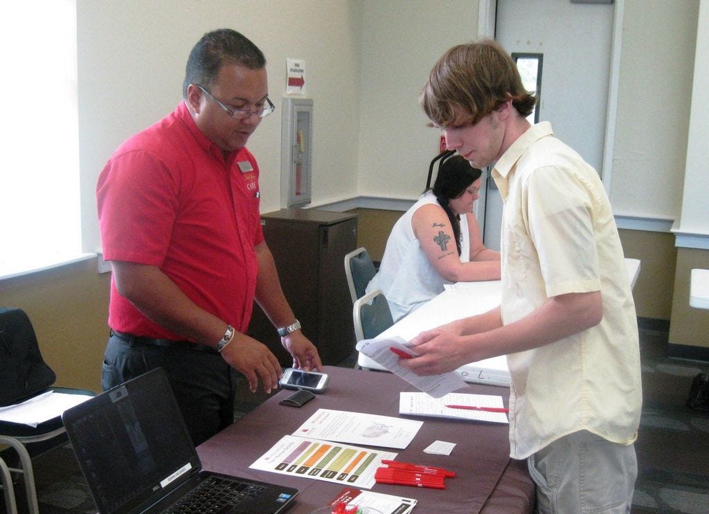 Michael May, right, discusses employment opportunities with recruiter Edwin Delgado of MasterCorp during the July 27 jobs fair at the Crestview Public Library.