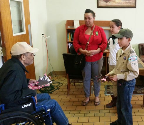 Boy Scout Bryson Blackmore (right), of Boy Scout Troop 773, delivers one of his scorpion valentines to to Crestview Manor resident Genisis Shy as his mom, Carmen, and sister, Danielle, watch Feb. 14 at the Crestview Manor.