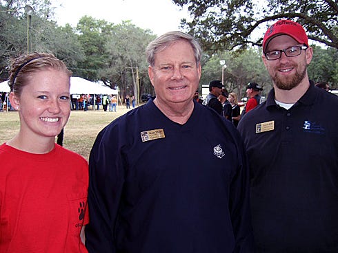 Jennifer Malone, of Crestview; Ken Hair, Children in Crisis Inc.'s president and CEO, center; and Travis Hill gather after the 34th Annual Toys for Tots Run.