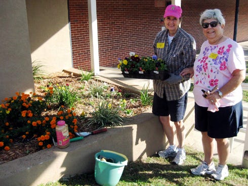 Dogwood Garden Club President Celia Broadhead and Master Gardener Ruth Herington prepare to plant flowers at Northwood Elementary School.