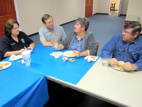 The Crestview Police Department's senior chaplain, the Rev. Mark Broadhead, second from left, chats with police dispatcher Toni Register, left, officer Wanda Hulion and her husband Mark.