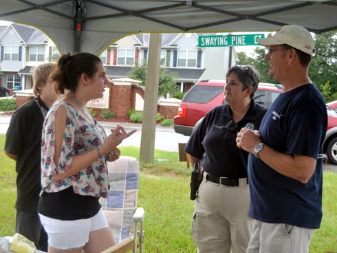 Kirsten Larson speaks with Crestview police officer Wanda Hulion and the Rev. Dale Walters during the Crestview Area Ministerial Association’s block party on Saturday in Rolling Pines.