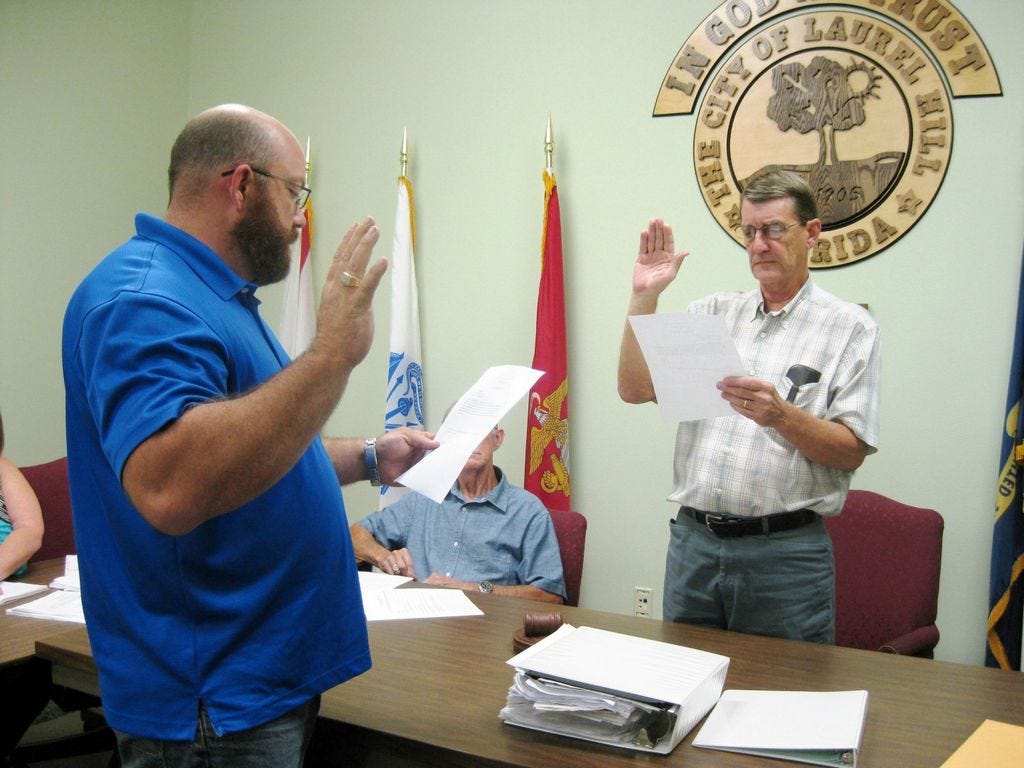 Laurel Hill City Council Chairman Larry Hendren swears new Councilman Travis Dewrell into office Nov. 5.