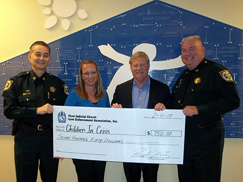 Children in Crisis — a nonprofit advocate for at-risk children — has an extra $750, with a donation from the First Judicial Circuit Law Enforcement Association. Pictured from left are Capt. Ron Gay, association president; Laura Moore, CIC volunteer and events coordinator; Ken Hair, CIC president and CEO; and Don Adams, Okaloosa County undersheriff. CIC will use the donation to support its kids' education.