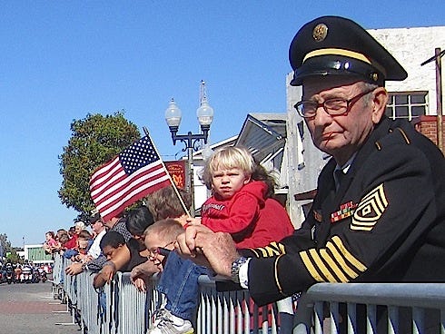 Retired 1st Sgt. George Ballard, still wearing his Army dress blues after 33 years of retirement, watches the Crestview Veterans Day Parade.