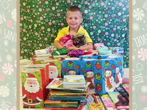 Jaedyn Williams, of Crestview, sits beside some of the gifts he recently distributed to patients at the Ronald McDonald House and Sacred Heart Children's Hospital.