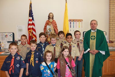 Pictured, back row: Boy Scout Johnny Humphrey, of Troop 773; Cub Scouts Jacek Zamorski, Waylon Hopwood and Tyler Dailey, of Pack 799; and Our Lady of Victory pastor, Monsignor Tugwell. Second row: Cub Scouts Ethan Bofinger, Bryce Zamorski and Benjamin Humphrey, of Pack 799; and Cub Scout Kelvin Lora, of Pack 532. Front row: Girl Scouts Bernadette Humphrey and Josey Humphrey, of Troop 738.