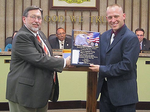 Mayor David Cadle, left, presents City Council President Ben Iannucci III a plaque from the Military Order of the Purple Heart officially naming Crestview a Purple Heart City.