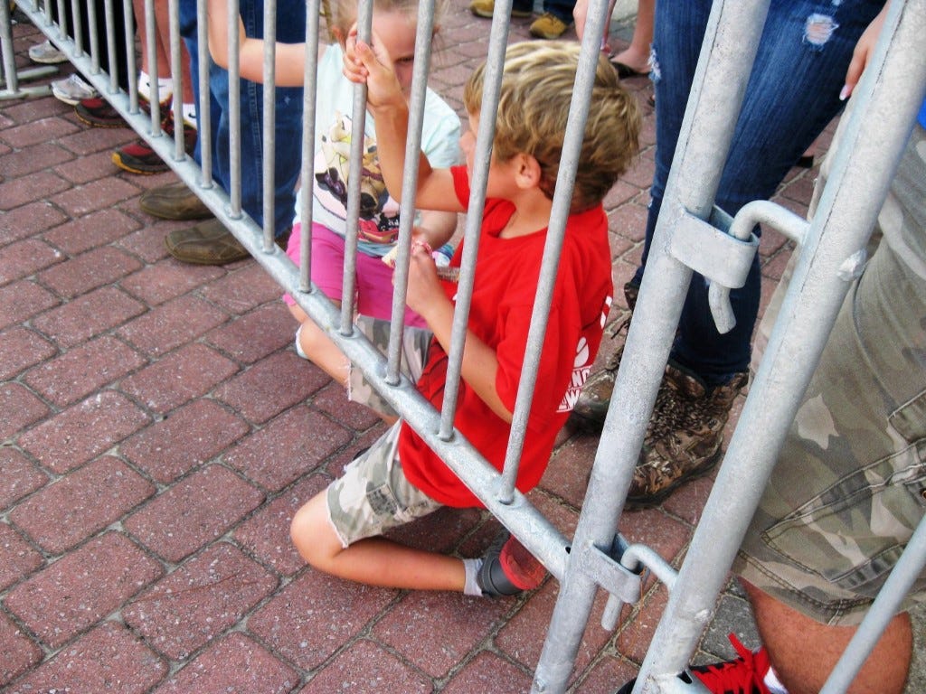 Xander Gray, 6, watches the Oct. 10 Crestview High School Homecoming parade from behind a crowd-control barricade. New barricades approved Monday night will assure the entire Main Street parade route is barricaded.