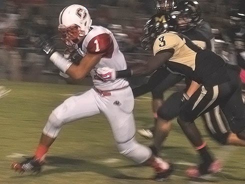 Crestview's Andrew Adkins can't shake a Milton defender during Friday's football game between the Bulldogs and Panthers.