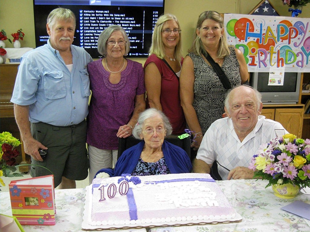 Children and grandchildren surprise Ruth Langdon on her 100th birthday. From left are grandson Rodney Beaman, his mother and Langdon’s daughter, Joan Hollmann, granddaughters Penny Blake and Candy Booe, and son Bob Langdon.