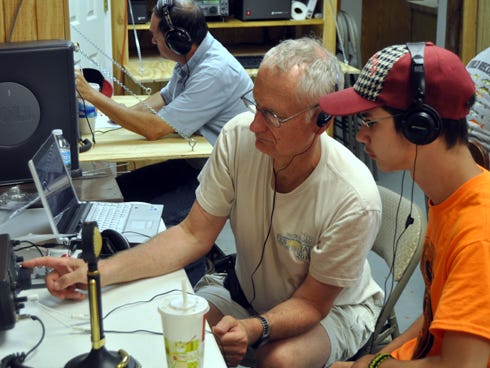 Mike Martell shows his grandson, Daniel Sainz, 17, how to operate a ham radio during the American Radio Relay League’s National Field Day on Saturday at Dorcas Fire Station 42.