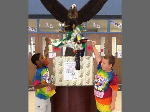 Riverside students, from left, Gabriel Campbell and Tyler Moore toss new pajamas into a donation box for the school's fourth annual Pajama Drive.