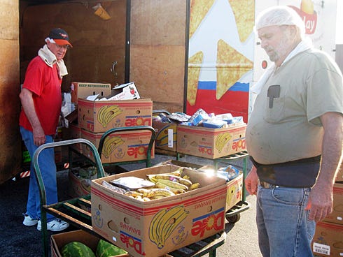Lonny Fuller and Gene Stanton load several hundred pounds of food provided by the Crestview Winn-Dixie. The food will help feed more than 1,000 needy residents per month.