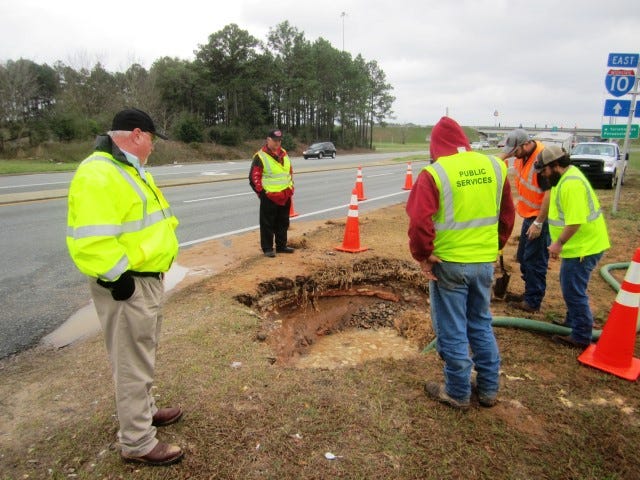 Public Works Director Wayne Steele observes as water is pumped out of the excavation around a burst 1960s water main along State Road 85 near the Applebee's restaurant.