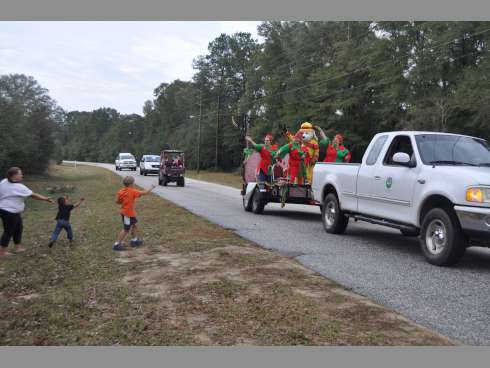 From left, Melissa Matthews, her 3-year-old son, Jeremiah, and Charlie Walsh, 6, catch candy from the city of Laurel Hill float as the Laurel Hill Christmas Parade travels down New Ebenezer Road on Saturday.