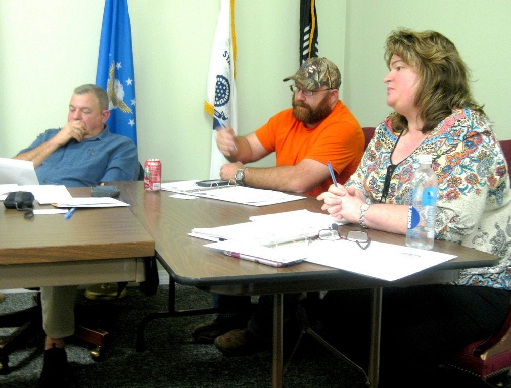 Laurel Hill City Council members Scott Moneypenny and Debra Adams listen as Councilman Travis Dewrell recommends modifying state purchasing guidelines to meet the city's typical budget and spending.