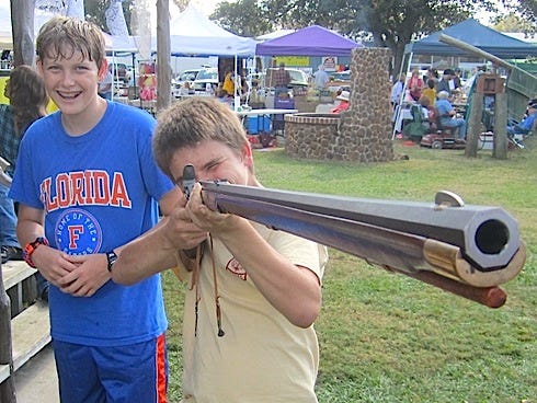 Danny Turner, a Baker School ninth-grader, draws a bead on a distant target with a colonial-era muzzle-loading rifle as his friend Wyatt Shumway enjoys the spectacle.