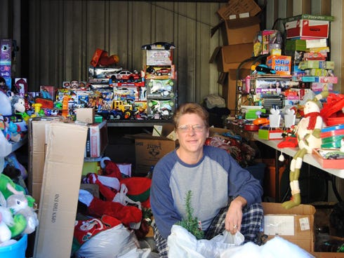 Hundreds of donated toys surround Christmas Angels in Crestview founder Renee Wiley at the organization's North Ferdon Boulevard storage unit. The Facebook-based group plans to distribute them before Dec. 25.