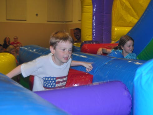 Cory Hannah, 8, and his sister Lauren, 6, race on an inflatable obstacle course on Wednesday night at Woodlawn Baptist Church. The church provided children with a "Back to School" event.