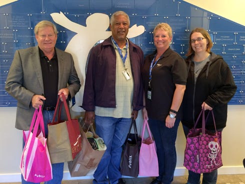 Ken Hair, Children in Crisis president and CEO, left, receives a donation of food and toys from InDyne Corporation employees Vernon Langford, Lacy Marlena and Meghan Arnett. The items will benefit children living at the CIC Neighborhood in Fort Walton Beach.