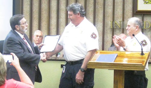 Fire Chief Joe Traylor applauds as Mayor David Cadle reads a commendation for Rodney Lancaster, Crestview's fire marshal and assistant chief for fire prevention, during the City Council's Feb. 22 meeting.