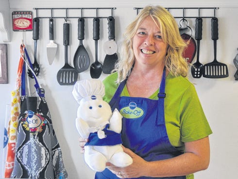 Dawn Onuffer, clutching a plush Pillsbury Doughboy in her kitchen, will compete in the 46th annual PIllsbury Bake-Off contest in November.