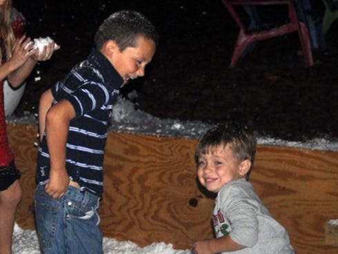 Kids play in a snow pit during Country Christmas, an Oliver's Nursery fundraiser, Saturday night in Holt.
