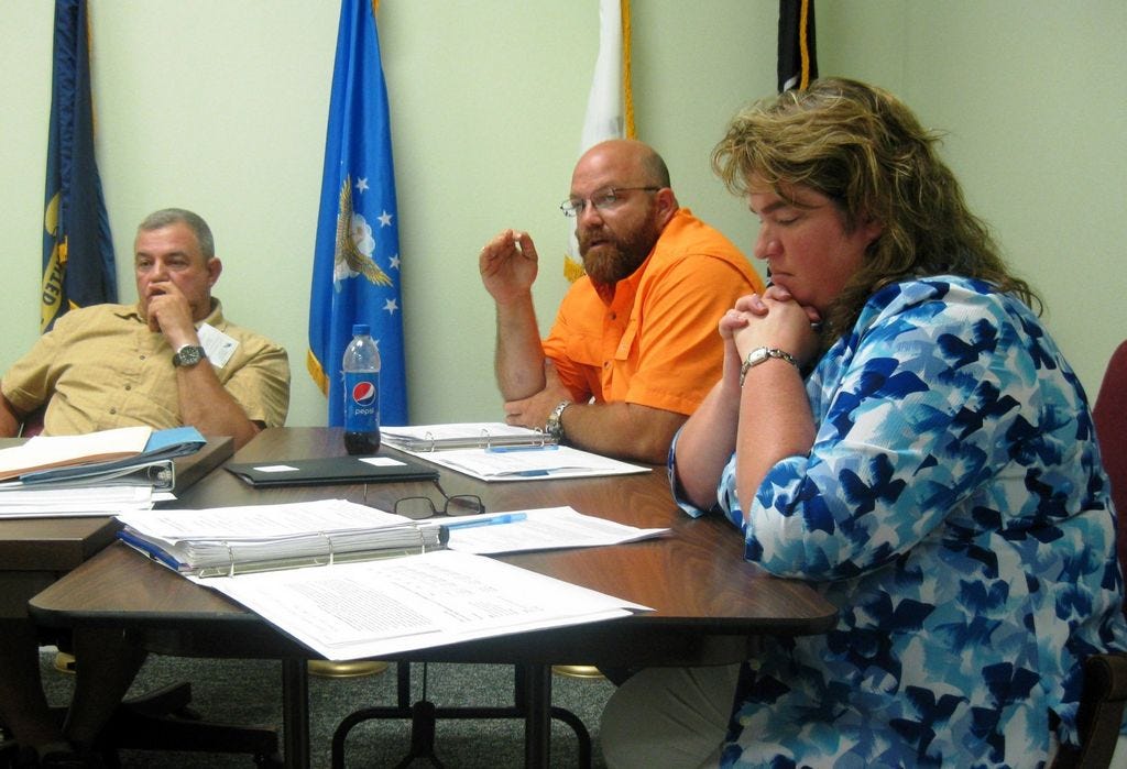 Councilman Travis Dewrell, center, discusses Laurel Hill's dissolution issue as council members Scott Moneypenny and Debra Adams listen.