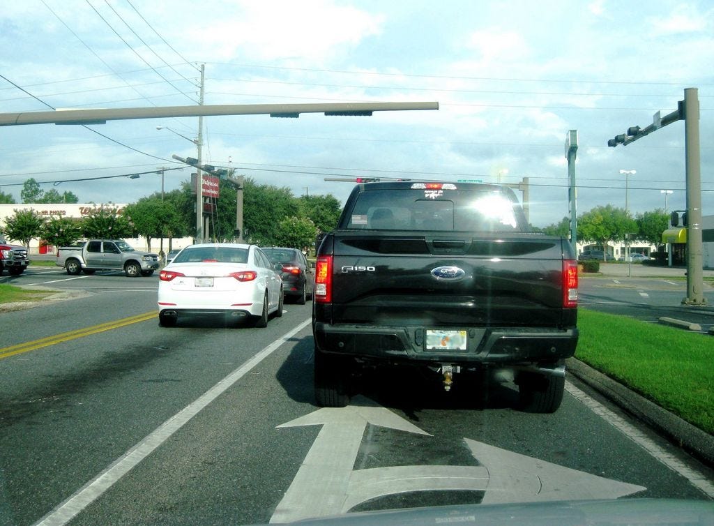 Is the truck going right or straight through the intersection of State Road 85 and Redstone Avenue? The white car was turning, as indicated by it being in a turn lane, not by use of its turn signals. (The truck went straight.)