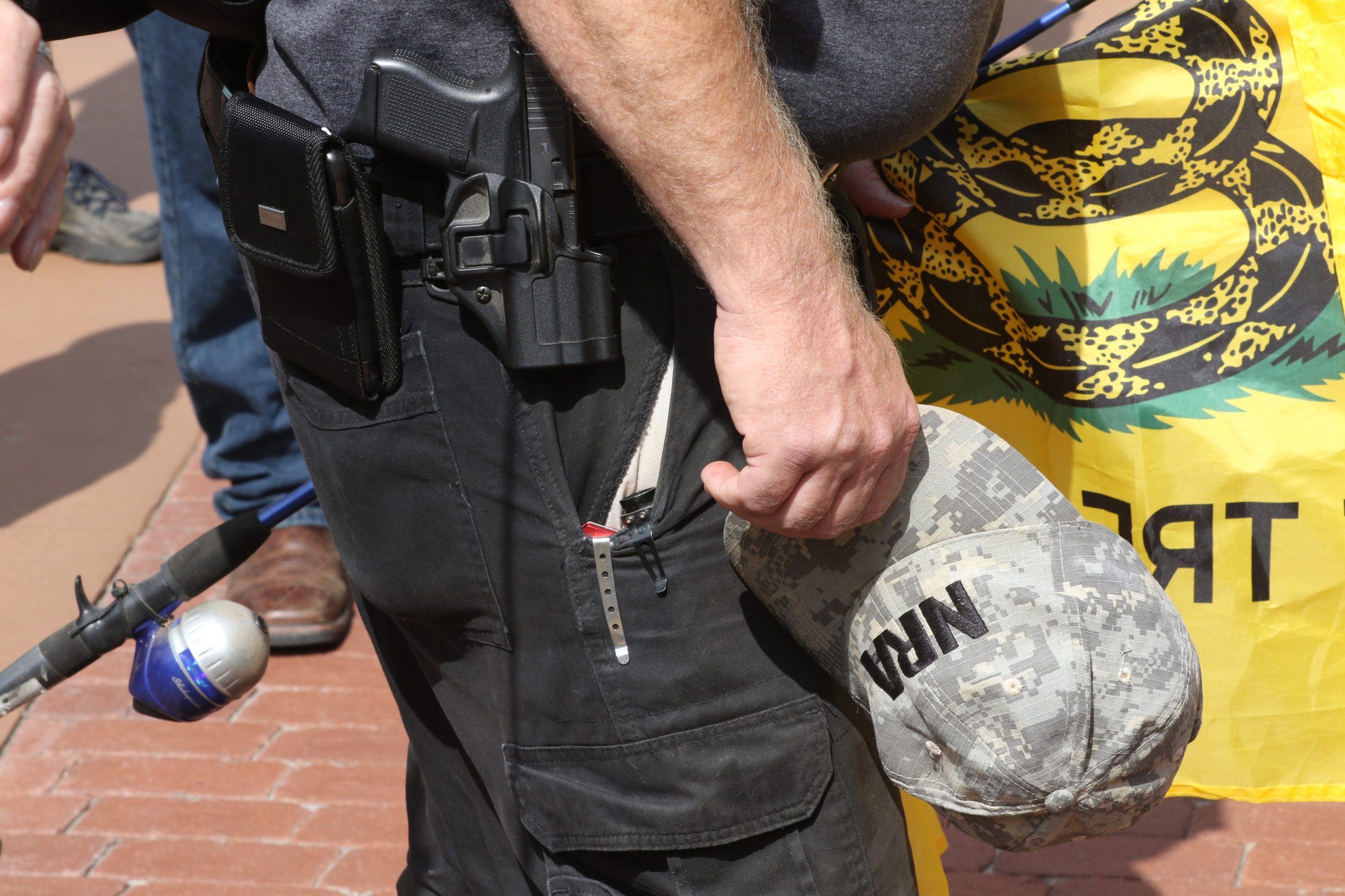 An NRA member takes off his hat as he pauses with other people to say the Pledge Of Allegiance and pray on the Ocala Downtown Square during an Open Carry March in April. [Gatehouse Media Florida File Photo]