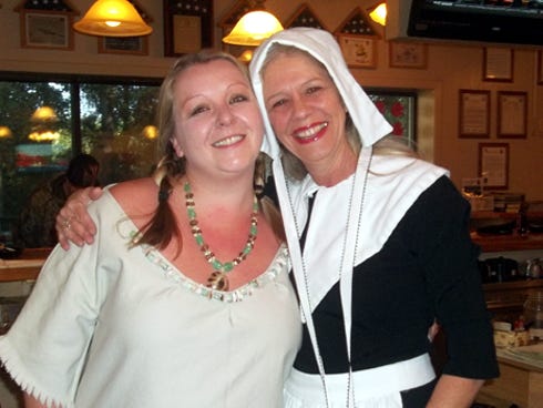 Rachael Bowles, AMVETS Post 35 lounge manager, and Suzy, a bartender, appeared as a Native American and pilgrim, respectively, while volunteers prepared Thanksgiving meals for needy residents.