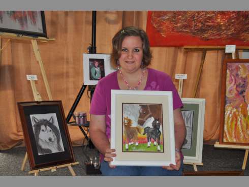 Jessica Bruegenhemke, 26, displays her painting of horses during Saturday’s reception for Java Journey Connection’s budding artist exhibit.