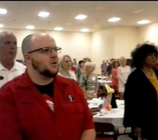Members of the Crestview Area Chamber of Commerce sing "God Bless America" during the June 2 monthly breakfast meeting in this video screen capture.
