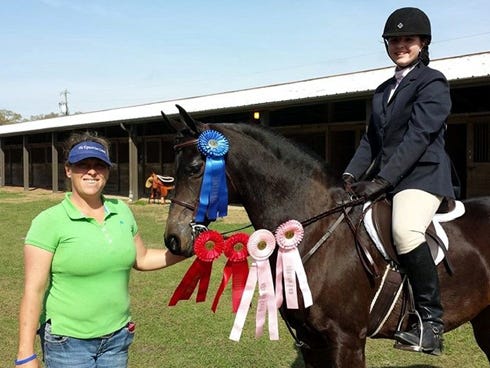 Horse trainer Devon Smith — with Hanna Greenfield, 12, riding her Arabian mare, Espania, following a recent Class A competition in Newberry, Fla. — is one of several trainers from The Equestrian Center in Fort Walton Beach helping to make a dream come true. Hanna wants to compete in the Arabian Horse Association Region XII competition in May.