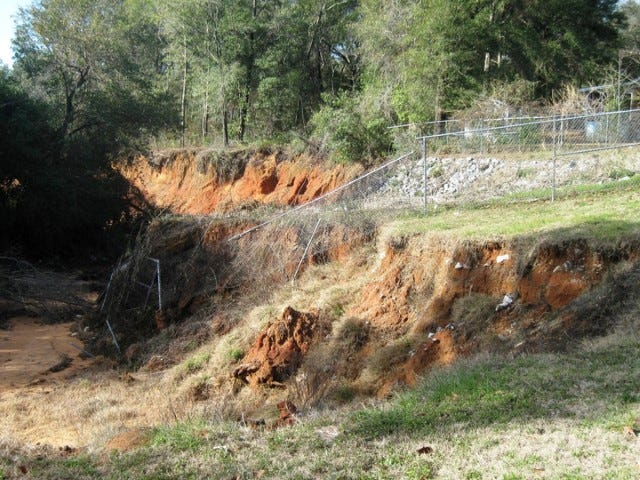 Fencing surrounding the first USDA erosion control structure has tumbled into the gullies created by April 2014 storm water erosion in the Gil-Ava storm water system.