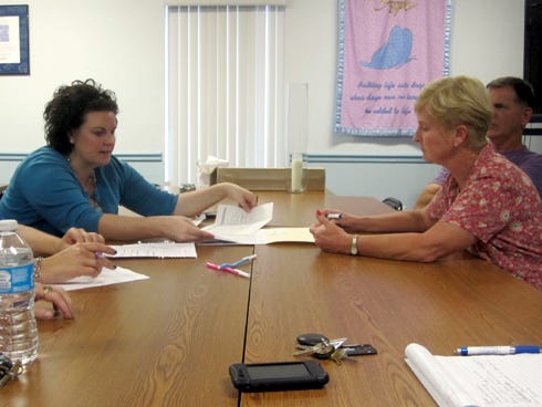 Covenant Hospice Development Manager Jenni Perkins, left, and volunteer Alice Fowler review plans for this year's Blue Jean Ball. Lou Fowler, also an event volunteer, sits next to his wife.