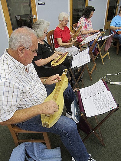 Members of the Niceville Noodlers mountain dulcimer band perform at the Crestview Public Library during a recent Music at the Library appearance.
